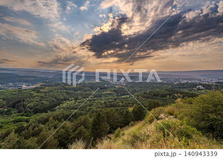 View of the mountains and Kislovodsk from the observation decks of the Kislovodsk Park. Evening sunset over the mountains of Kislovodsk. View of the mountains and Kislovodsk from the observation decks of the Kislovodsk Park. Evening sunset over the mountains of Kislovodsk. 140943339