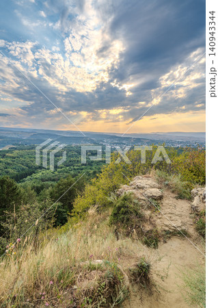 View of the mountains and Kislovodsk from the observation decks of the Kislovodsk Park. Evening sunset over the mountains of Kislovodsk. View of the mountains and Kislovodsk from the observation decks of the Kislovodsk Park. Evening sunset over the mountains of Kislovodsk. 140943344