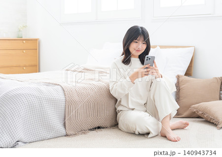 寝室でスマホを使う女性 寝室でスマホを使う女性 140943734