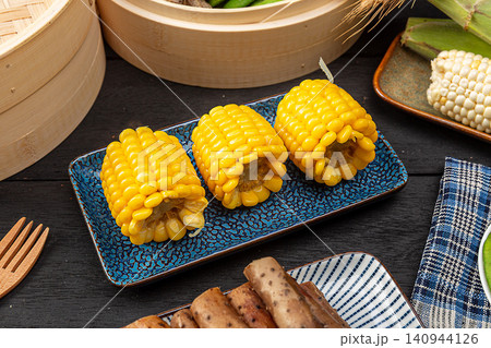 Boiled sweet corn on the cob chunks on blue plate, healthy Chinese snack 140944126