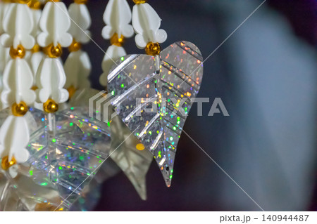 Closeup of sparkling crystal leaf hanging ornament white floral beads reflecting colorful light ideal for decoration celebration luxury craft elegant interior themes Closeup of sparkling crystal leaf hanging ornament white floral beads reflecting colorful light ideal for decoration celebration luxury craft elegant interior themes 140944487