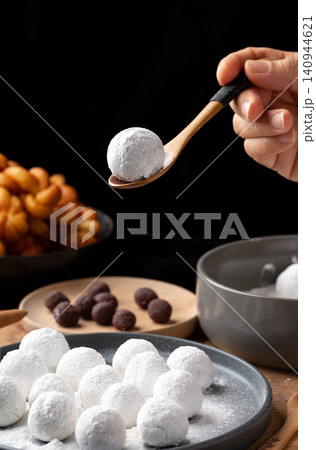 rolling sweet glutinous rice ball in hand, traditional handmade Tangyuan mochi preparation rolling sweet glutinous rice ball in hand, traditional handmade Tangyuan mochi preparation 140944621