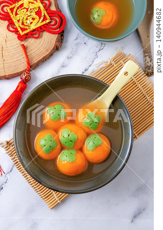 cooked persimmon shaped sweet rice ball with flowing black sesame filling, authentic festive Chinese Tangyuan dessert 140944682