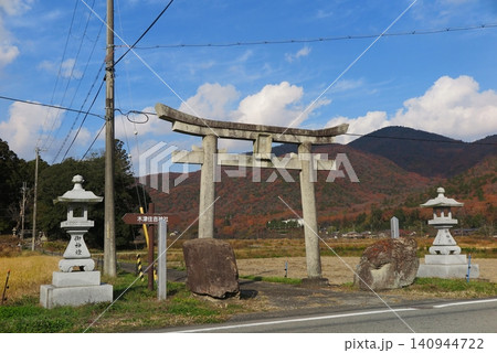 秋の里山、道路脇に鎮座する神社の鳥居と石灯籠 140944722