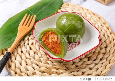 traditional green rice balls with salted egg yolk and pork floss filling, savory Qingtuan mochi on bamboo mat traditional green rice balls with salted egg yolk and pork floss filling, savory Qingtuan mochi on bamboo mat 140945087
