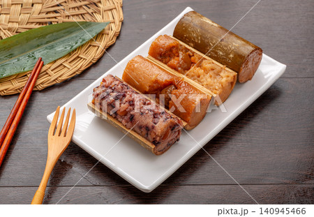assortment of steamed sweet and savory zongzi dumplings featuring red bean, purple rice, and meat flavors. assortment of steamed sweet and savory zongzi dumplings featuring red bean, purple rice, and meat flavors. 140945466