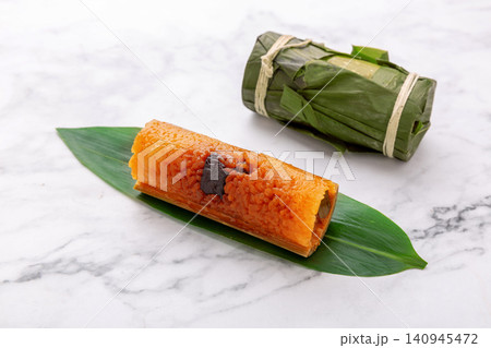steamed sweet glutinous rice zongzi cooked in bamboo tube and filled with red dates. 140945472