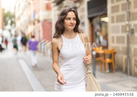 Young woman walks along city street Young woman walks along city street 140945538