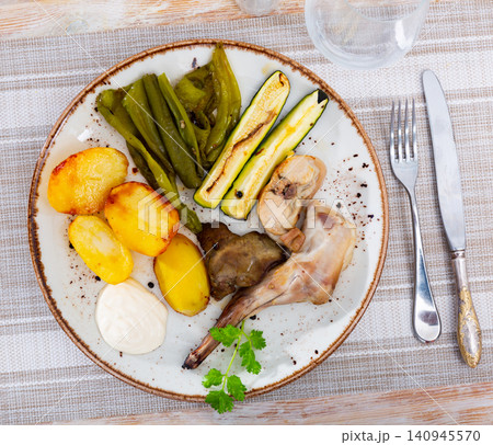 Roasted rabbit served with vegetable garnish Roasted rabbit served with vegetable garnish 140945570