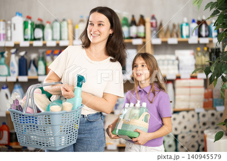 Portrait of family with full shopping basket in home goods store Portrait of family with full shopping basket in home goods store 140945579