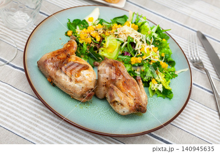 Fried quail garnished with portion of fresh vegetable salad 140945635