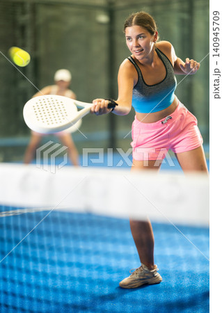 Portrait of girl paddle tennis player during friendly doubles couple match at court Portrait of girl paddle tennis player during friendly doubles couple match at court 140945709