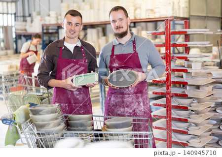 Two potters holding handcrafted ceramic plates in pottery workshop Two potters holding handcrafted ceramic plates in pottery workshop 140945710