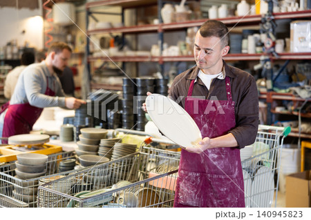 Young man posing with ceramic dishes 140945823