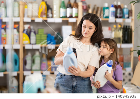 Woman and girl clients, by scanning QR code, gains access to information about liquid detergent 140945938