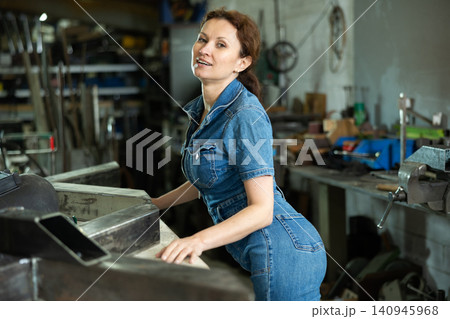 Woman employee of carpentry workshop took time out from work, stands resting 140945968