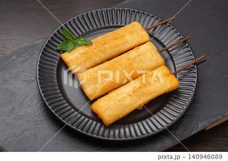 deep fried crispy rice cake skewers garnished with fresh mint leaf. 140946089