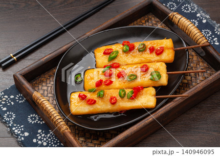 fried rice cake skewers seasoned with sliced red and green chili peppers. fried rice cake skewers seasoned with sliced red and green chili peppers. 140946095