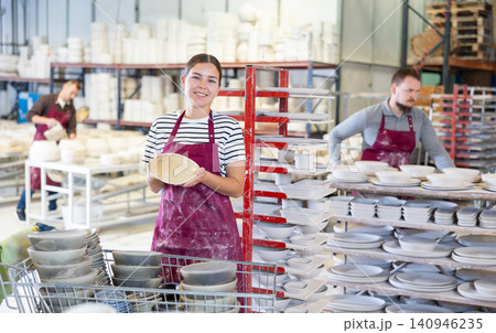 Young woman posing with ceramic dishes Young woman posing with ceramic dishes 140946235