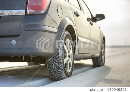 Close up of a car tire parked on snowy road on winter day. Transportation and safety concept. Close up of a car tire parked on snowy road on winter day. Transportation and safety concept. 140946291