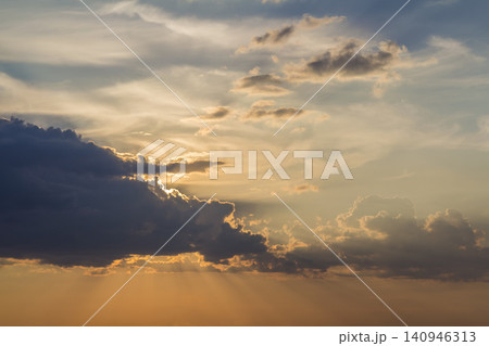 Panorama of sky at sunrise or sunset. Beautiful view of dark blue clouds lit by bright orange yellow sun on clear sky. Beauty and power of nature, meteorology and climate changing concept. Panorama of sky at sunrise or sunset. Beautiful view of dark blue clouds lit by bright orange yellow sun on clear sky. Beauty and power of nature, meteorology and climate changing concept. 140946313