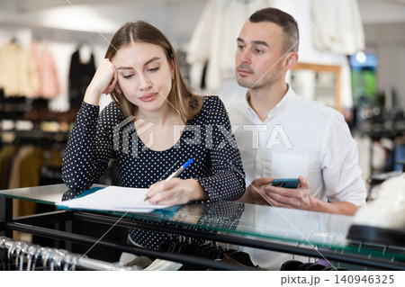 Man with phone in hands participates in discussion of business development plans with wife Man with phone in hands participates in discussion of business development plans with wife 140946325