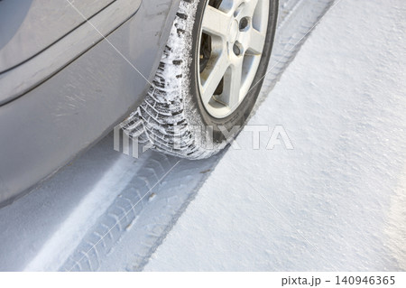 Close-up of car wheels rubber tire in deep snow. Transportation and safety concept. Close-up of car wheels rubber tire in deep snow. Transportation and safety concept. 140946365