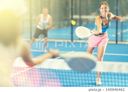 Young woman and man playing tennis against woman Young woman and man playing tennis against woman 140946462