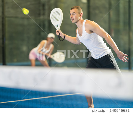 Active man with enthusiasm playing padel on tennis court Active man with enthusiasm playing padel on tennis court 140946681