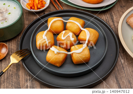 crispy Golden Fried Bun Dipping in Sweet Condensed Milk Delicious Asian Dessert crispy Golden Fried Bun Dipping in Sweet Condensed Milk Delicious Asian Dessert 140947012