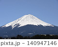 青空の下でベッタリ冠雪して白く化粧した富士山頂と森林限界以下の木々に着雪して鼠色になった樹林の裾野 140947146