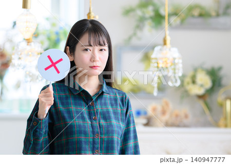 バツ印の札を持つ女性の顔 バツ印の札を持つ女性の顔 140947777
