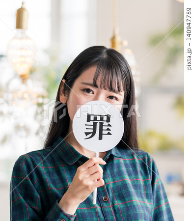 罪の文字が書かれた団扇を持つ女性 罪の文字が書かれた団扇を持つ女性 140947789