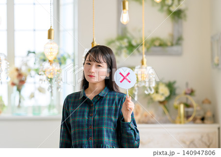×印の札を持つ真剣な表情の女性 ×印の札を持つ真剣な表情の女性 140947806