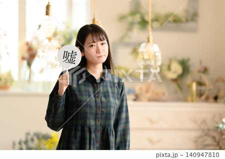 嘘の文字プレートを持つ若い女性 嘘の文字プレートを持つ若い女性 140947810