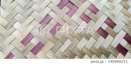 Natural bamboo weave pattern background with pink and cream-colored stripes. 140948251