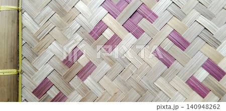 Traditional woven bamboo texture with a geometric pattern in natural cream and pink. Traditional woven bamboo texture with a geometric pattern in natural cream and pink. 140948262