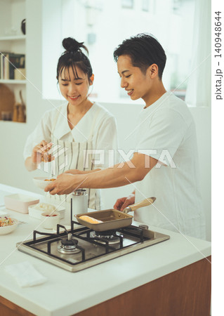 明るいキッチンで2人並んでお弁当を作るカップル 140948644