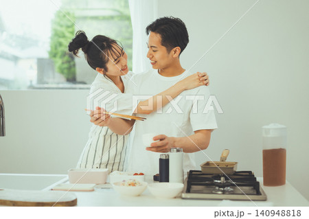 キッチンで料理中に男性に寄り添う笑顔のカップル 140948818
