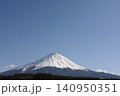広い青空の下で三峰型山頂で長辺三角形の安定した形でどっしりとそびえたつ純白に冠雪した富士山 140950351