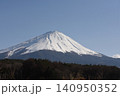 広い青空の下で三峰型山頂で長辺三角形の安定した形でどっしりとそびえたつ純白に冠雪した富士山 140950352