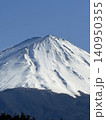 青空の下で三峰型山頂で安定した形でどっしりとそびえたつ純白に冠雪した富士山 140950355
