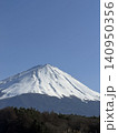 広い青空の下で三峰型山頂のどっしりとそびえたつ純白に冠雪した富士山 140950356