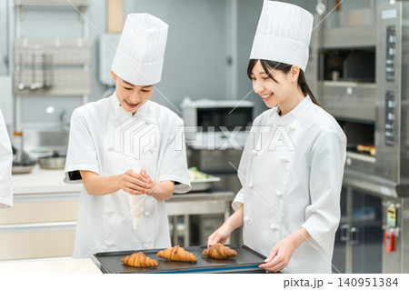 厨房でパン,ケーキ,洋菓子を作るパティシエ,ケーキ職人,洋菓子職人の女性スタッフ 厨房でパン,ケーキ,洋菓子を作るパティシエ,ケーキ職人,洋菓子職人の女性スタッフ 140951384