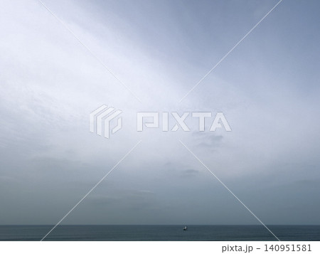 厚い雲が広がる海と小さな船のミニマルな風景 厚い雲が広がる海と小さな船のミニマルな風景 140951581