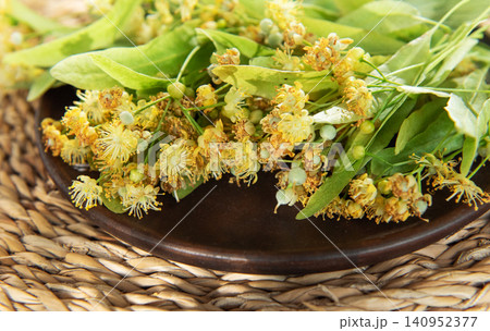 Linden tree blossoms on a dark plate preparing herbal tea 140952377