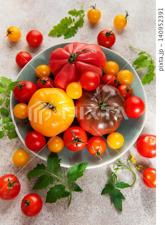Fresh farm tomatoes displaying colorful variety on a plate Fresh farm tomatoes displaying colorful variety on a plate 140952391