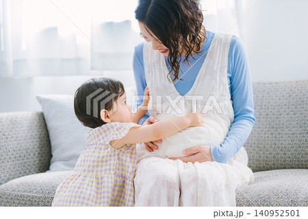 リビングで妊婦のお母さんに甘える女の子 リビングで妊婦のお母さんに甘える女の子 140952501