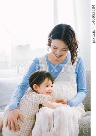 リビングで妊婦のお母さんに甘える女の子 リビングで妊婦のお母さんに甘える女の子 140952504