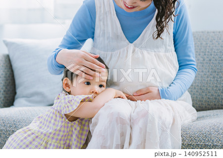 リビングで妊婦のお母さんに甘える女の子 140952511
